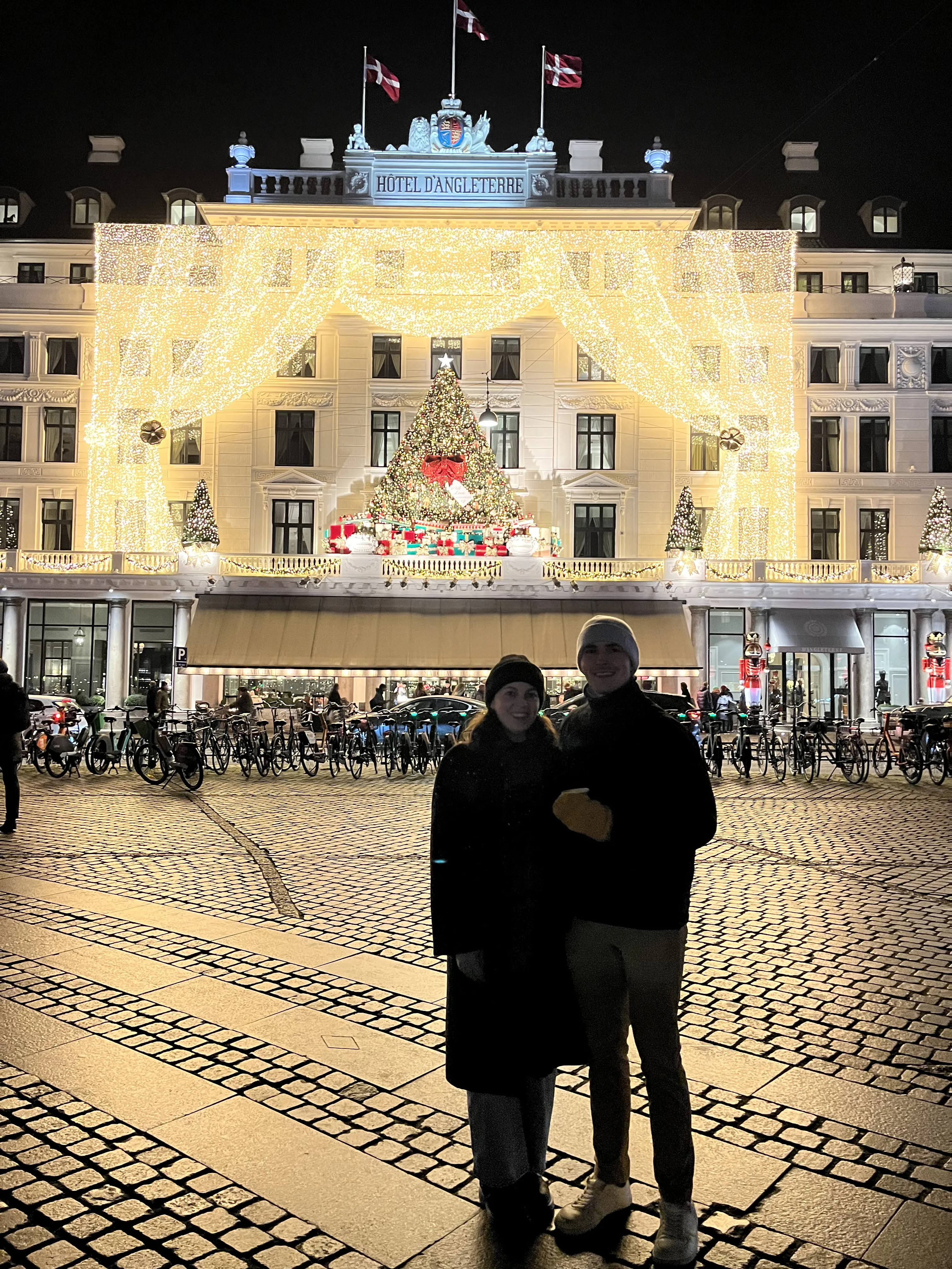 James and Emily in front of a Christmas market building.